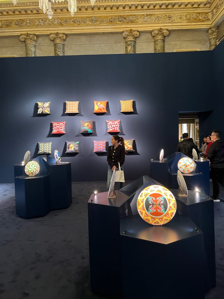 a woman standing in a room with art on display